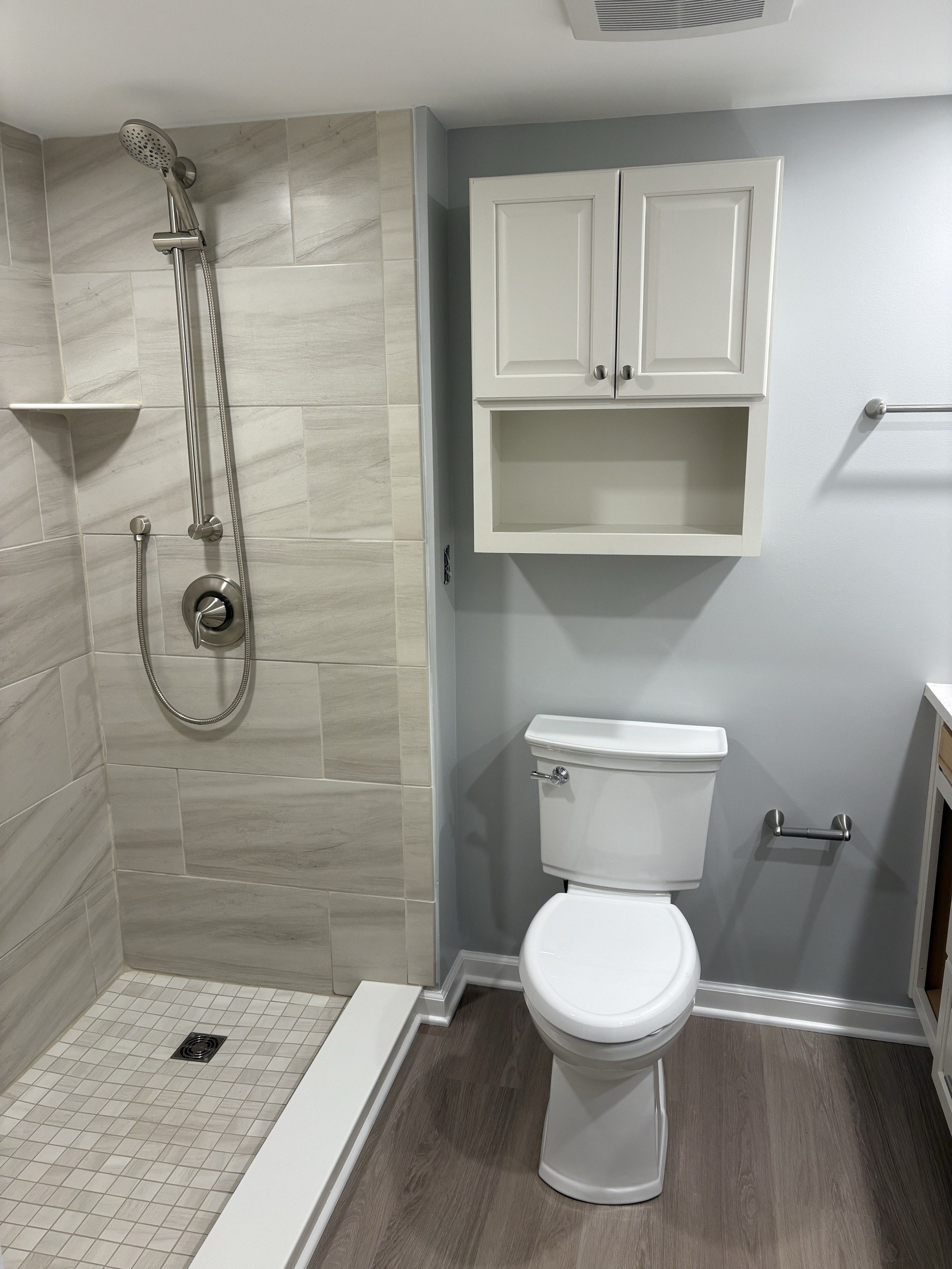 Full tile bathroom with glass shower and built-in cabinet
