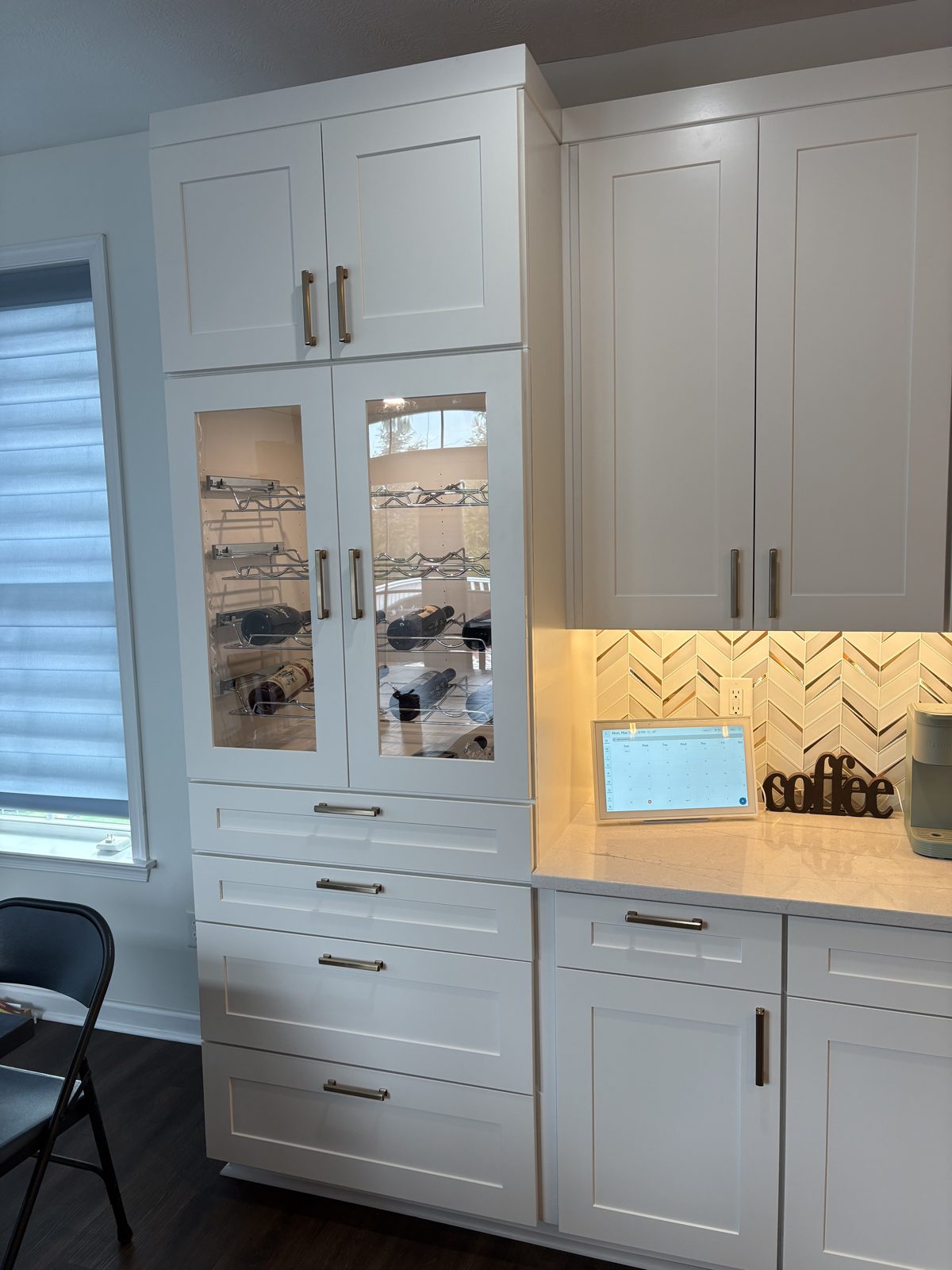 Built-in coffee bar with glass-front cabinets and a herringbone backsplash