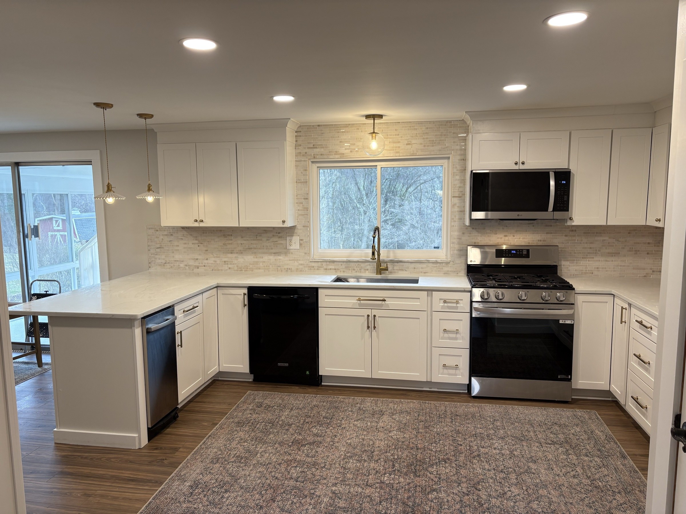 White shaker kitchen with gas range and stone backsplash