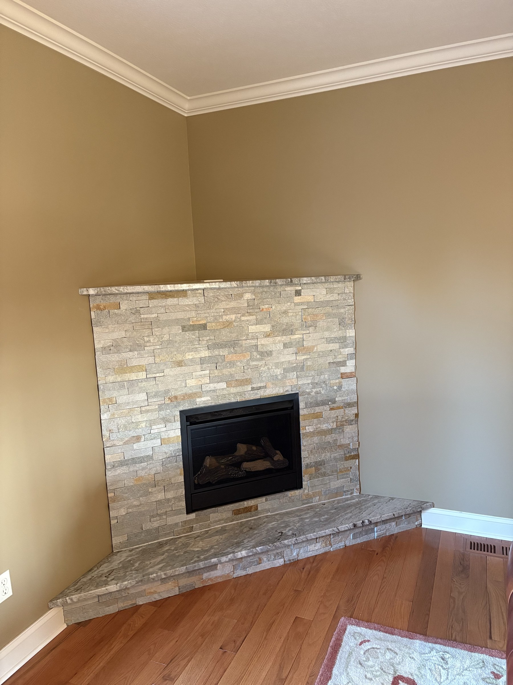 Painted warm taupe walls around a stacked-stone fireplace