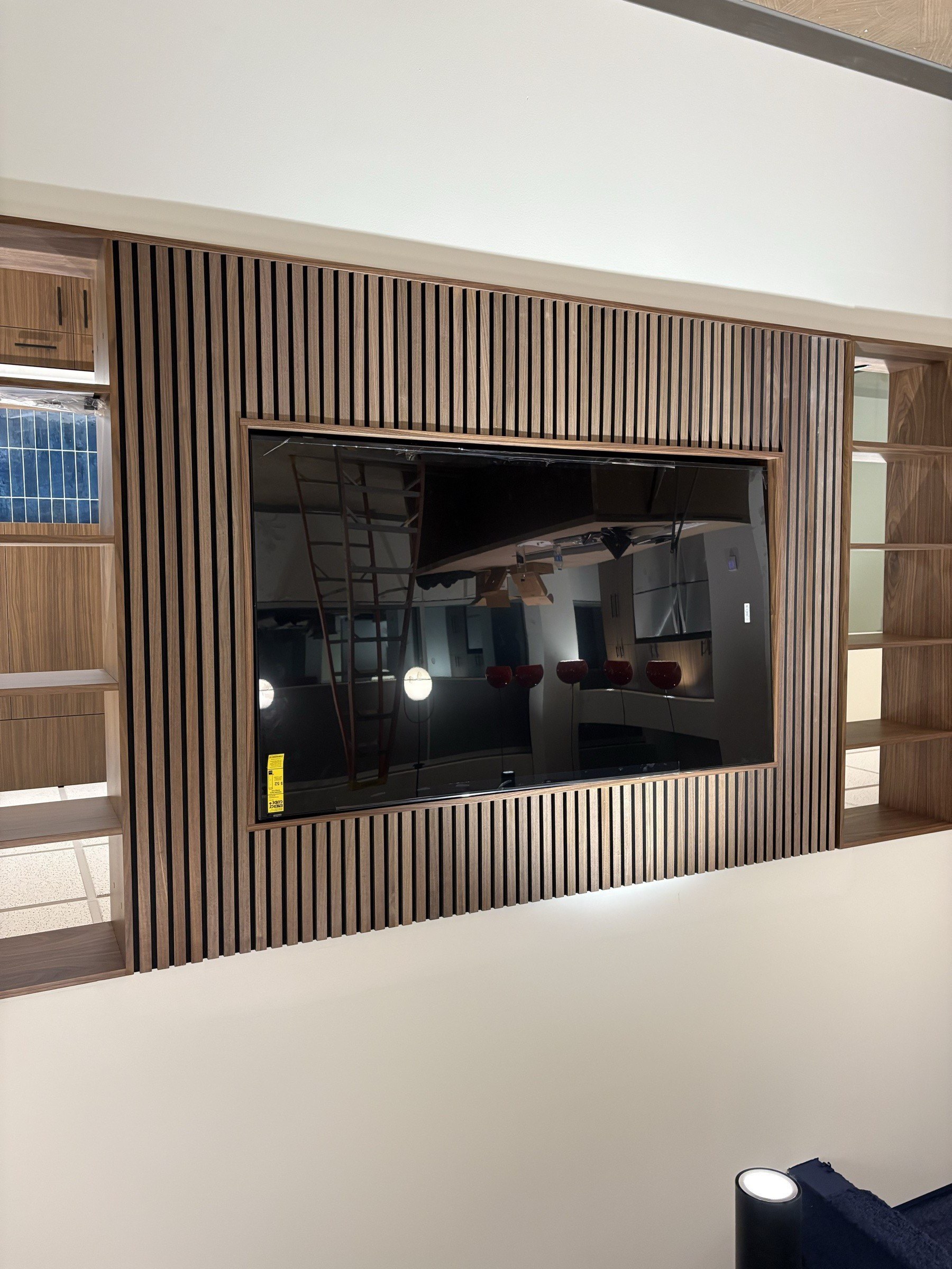 Custom wood-slat accent wall with mounted TV
